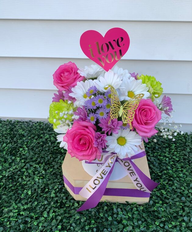 a charming small bouquet featuring a delightful mix of white and purple daisies and pink carnations.