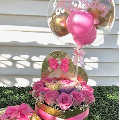 Pink roses arranged in a gold heart shaped box