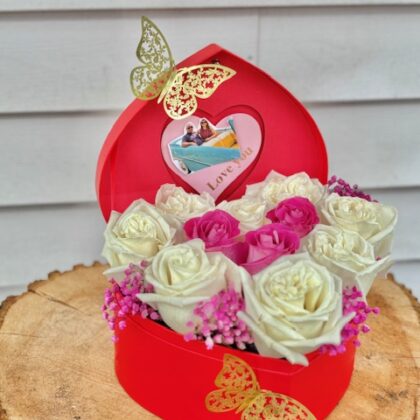 white roses and pink rose in a lovely red heart shaped box