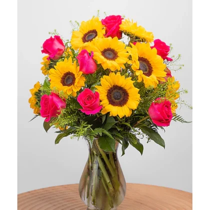 Pink roses and sunflowers arranged in a vase